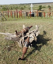 На холме памяти установлены кресты с фамилиями жителей уничтоженных сел и композиции из неразорвавшихся снарядов с бывшего полигона