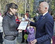 Глава Малиновской райадминистрации Евгений Омельчук вручает почетную грамоту городского головы активной участнице обустройства площадки Надежде Драгут