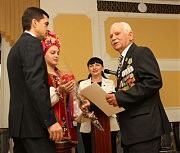 Заместитель главы облгосадминистрации Владимир Жмак вручает поздравительное письмо Президента Украины Петра Порошенко кавалеру четырех медалей «За отвагу» Алексею Ефимовичу Прокофьеву