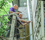 Кровельщики Владимир Буханченко и Виктор Бережной меняют водосточную трубу